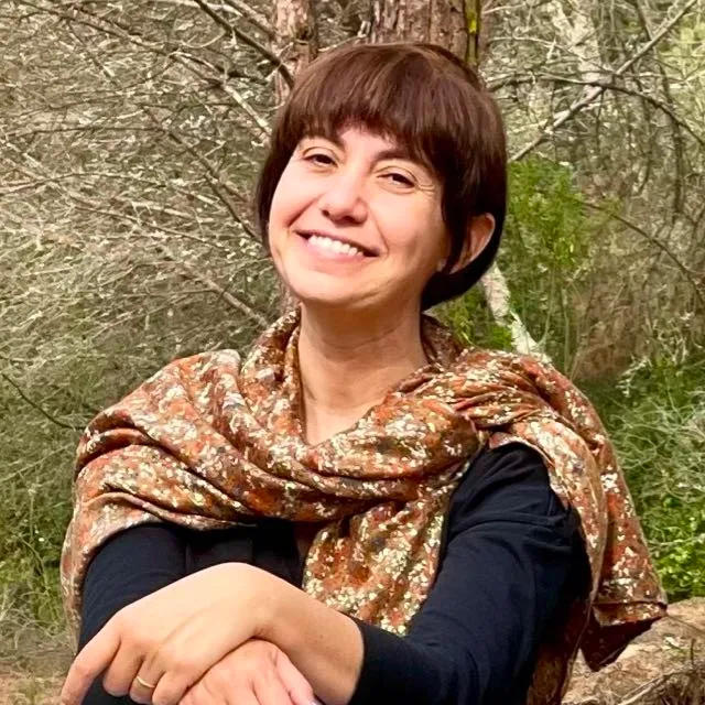 Retrat professional d'una psicòloga amb un somriure càlid i empàtic, il·luminació natural suau, fons neutre